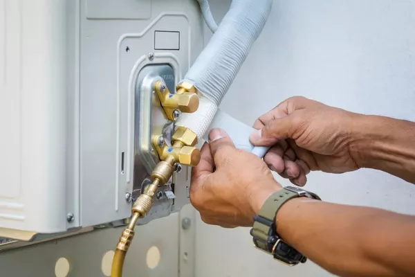 tech repairing hvac hose